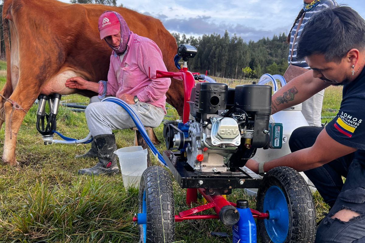 Dos técnicos de deOrdeño poniendo en marcha un equipo EcoMilk con la vaca ya conectada